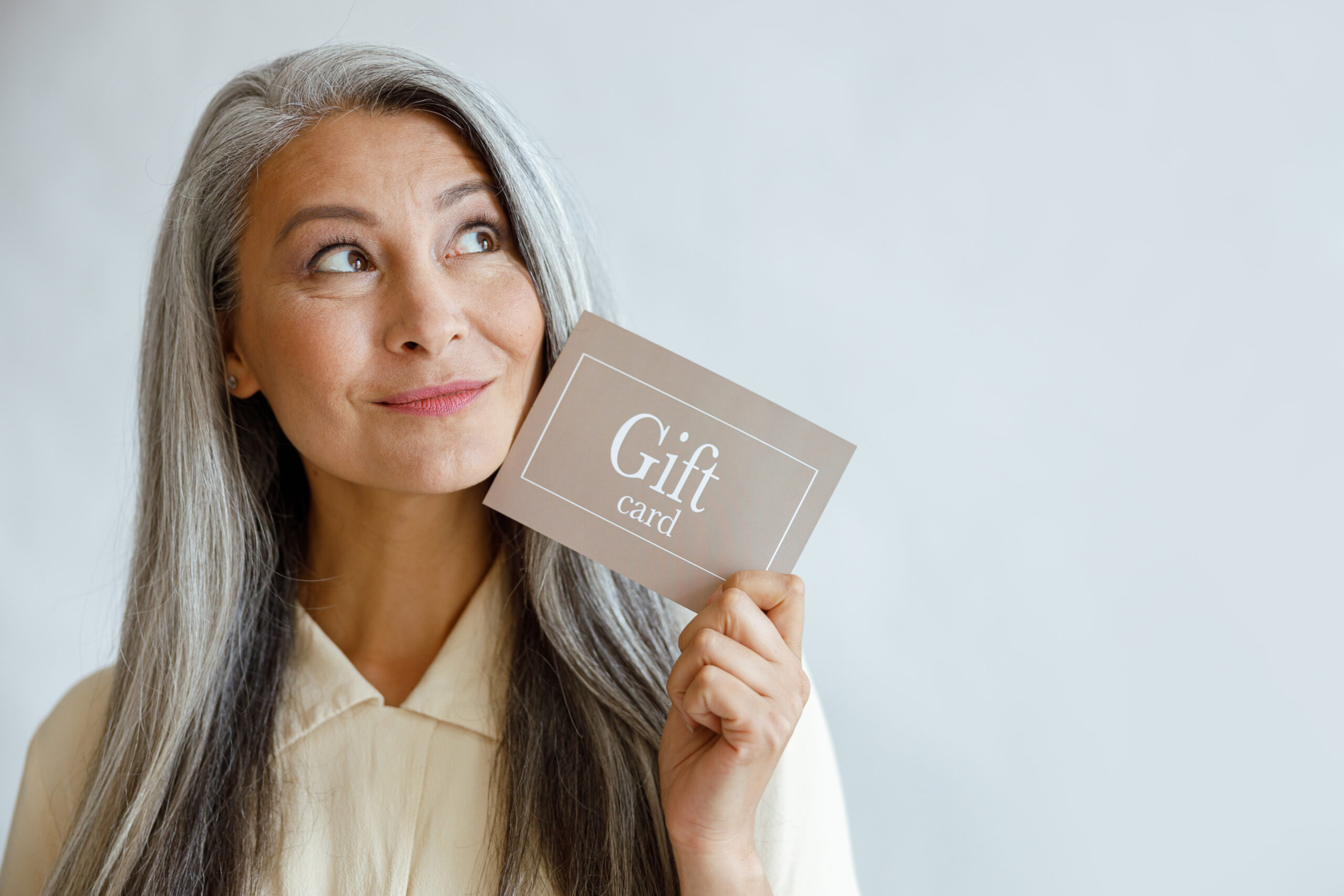 Woman holding a gift card with a smile